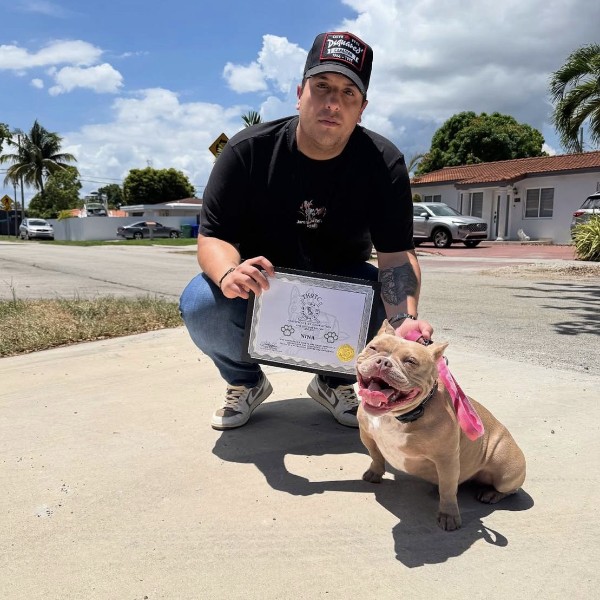 Client with their dog and training certificate